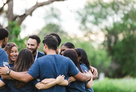 group-of-adults-holding-arms-in-a-circle